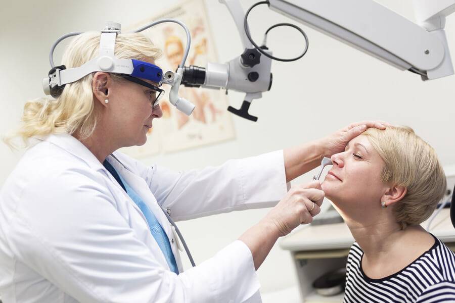 Осмотр врача при синусите.